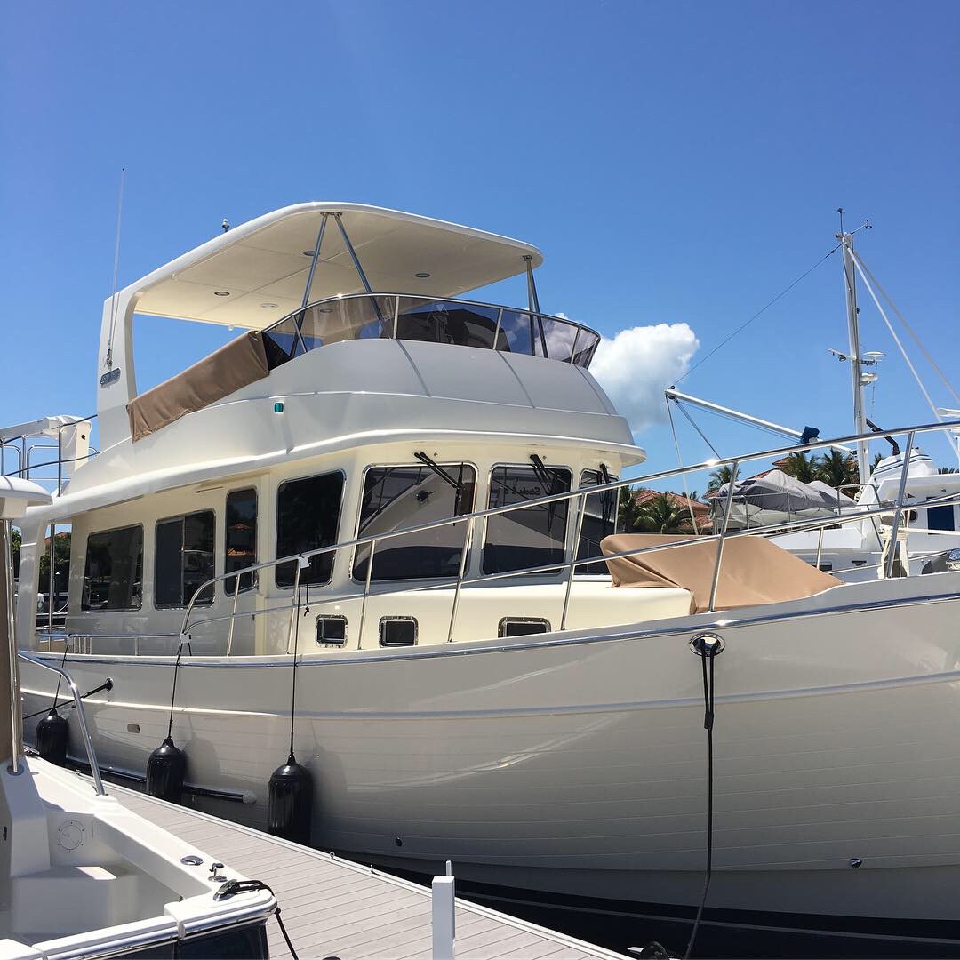 Cream-colored yacht at marina with tinted windows