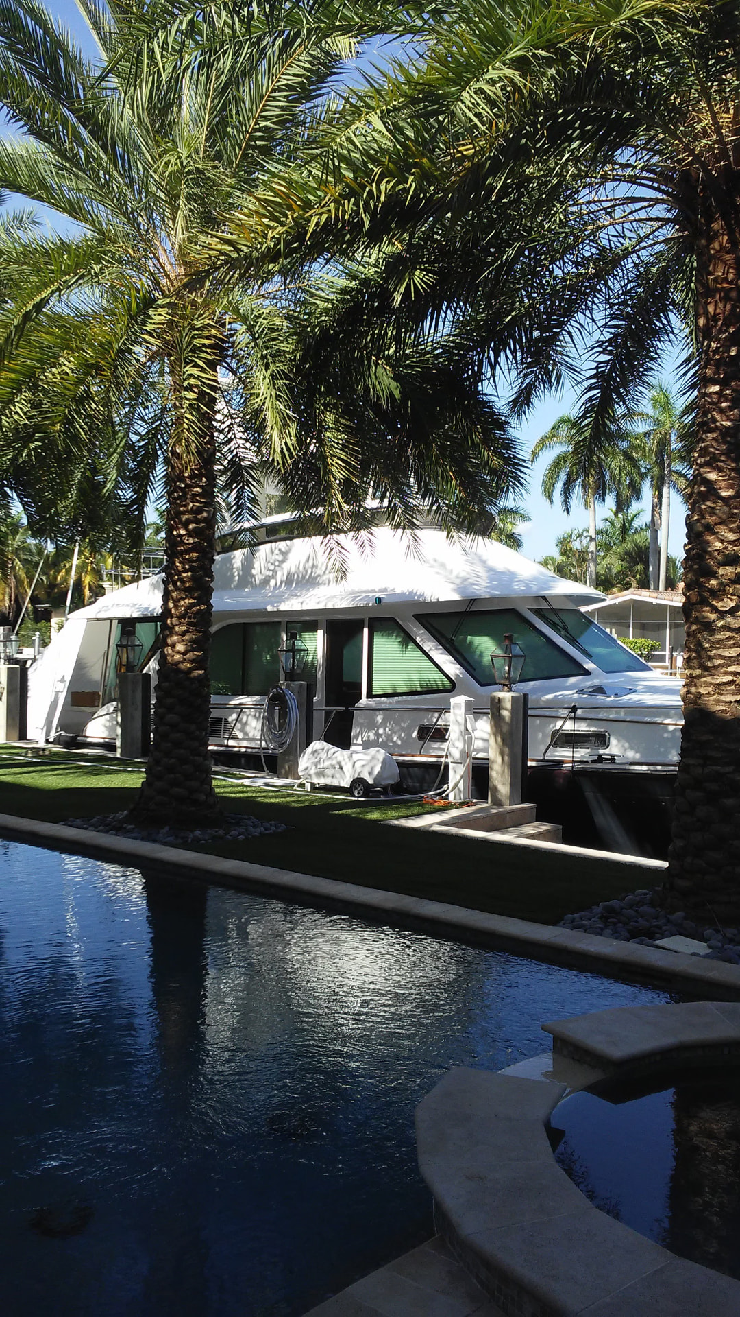 Yacht docked alongside palm trees with tinted cabin windows